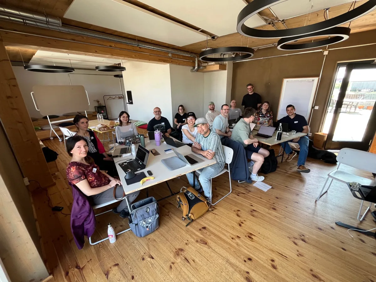Workshop participants with their laptops around the tables at Impact Hub Berlin